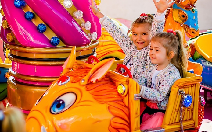 Children enjoying a colorful ride at Energylandia amusement park.