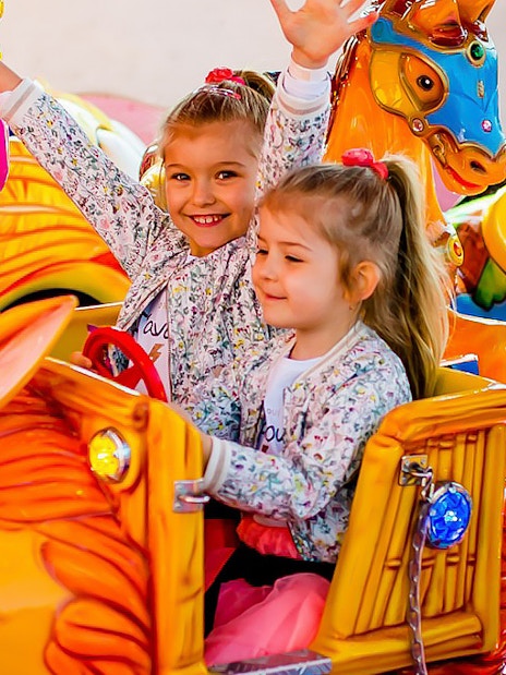 Children enjoying a colorful ride at Energylandia amusement park.