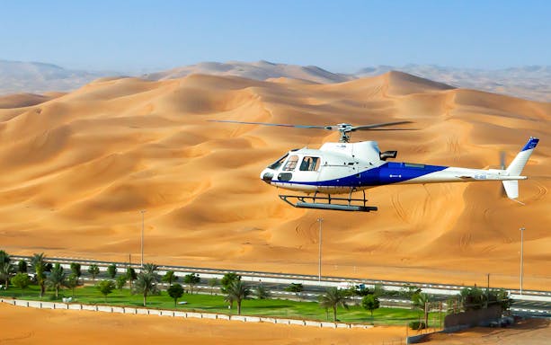 Helicopter flying over desert dunes during Grand Helicopter Tour.