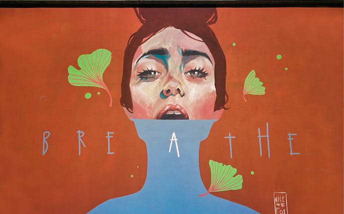 Mural of a woman's face with "BREATHE" text at Museo d'Arte Orientale.