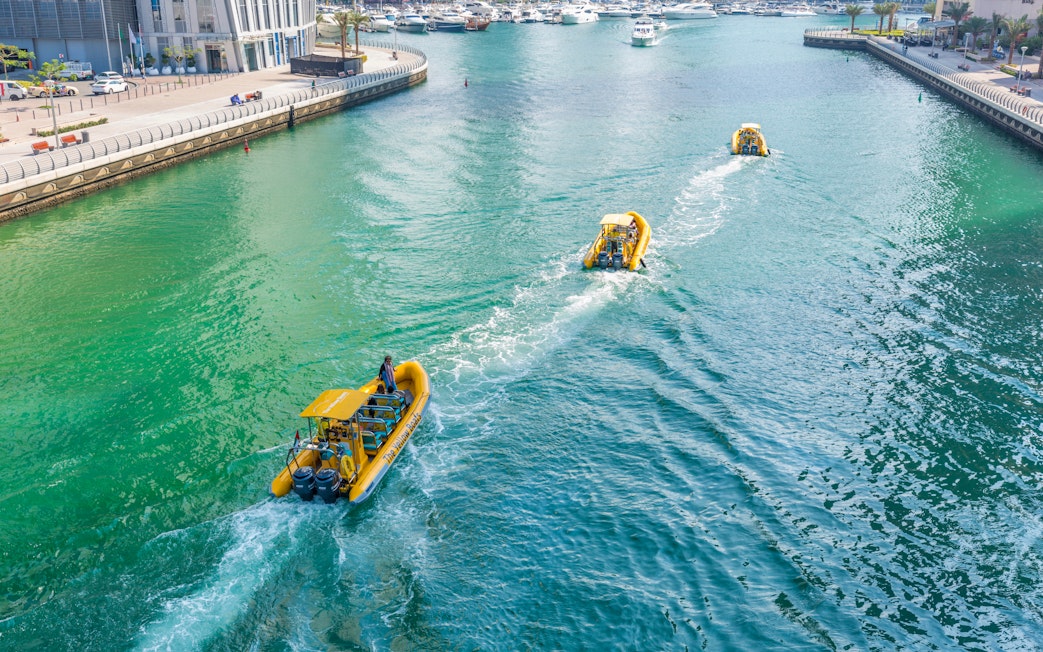 Speedboat cruising past Dubai Marina skyscrapers on a guided tour.
