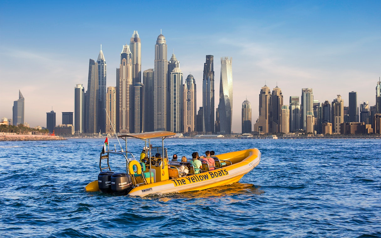 Speedboat tour in Dubai Marina with city skyline in the background.