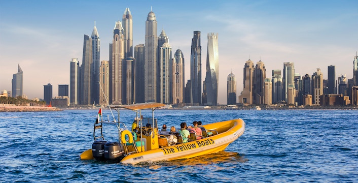 Speedboat tour in Dubai Marina with city skyline in the background.