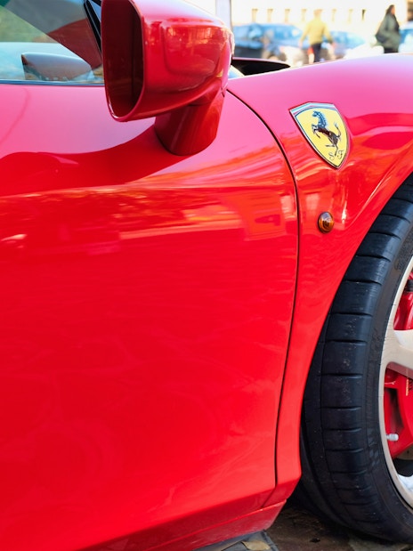 Ferrari 458 Italia close-up in Maranello, showcasing wheel and emblem.