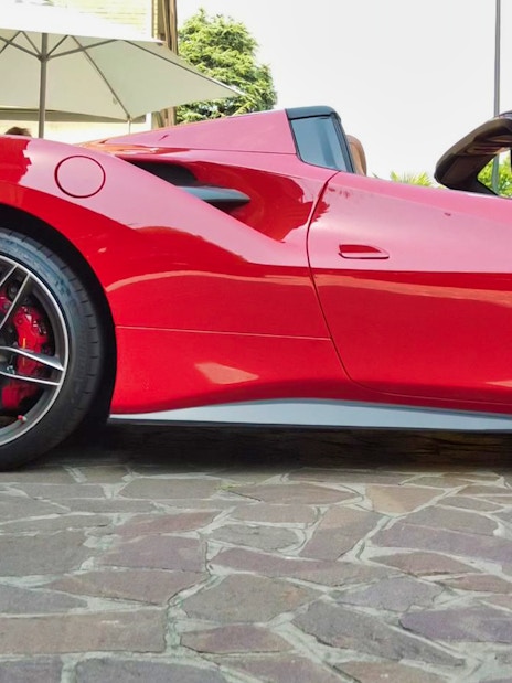Ferrari 488 Spider parked on cobblestone street, ready for test drive experience.