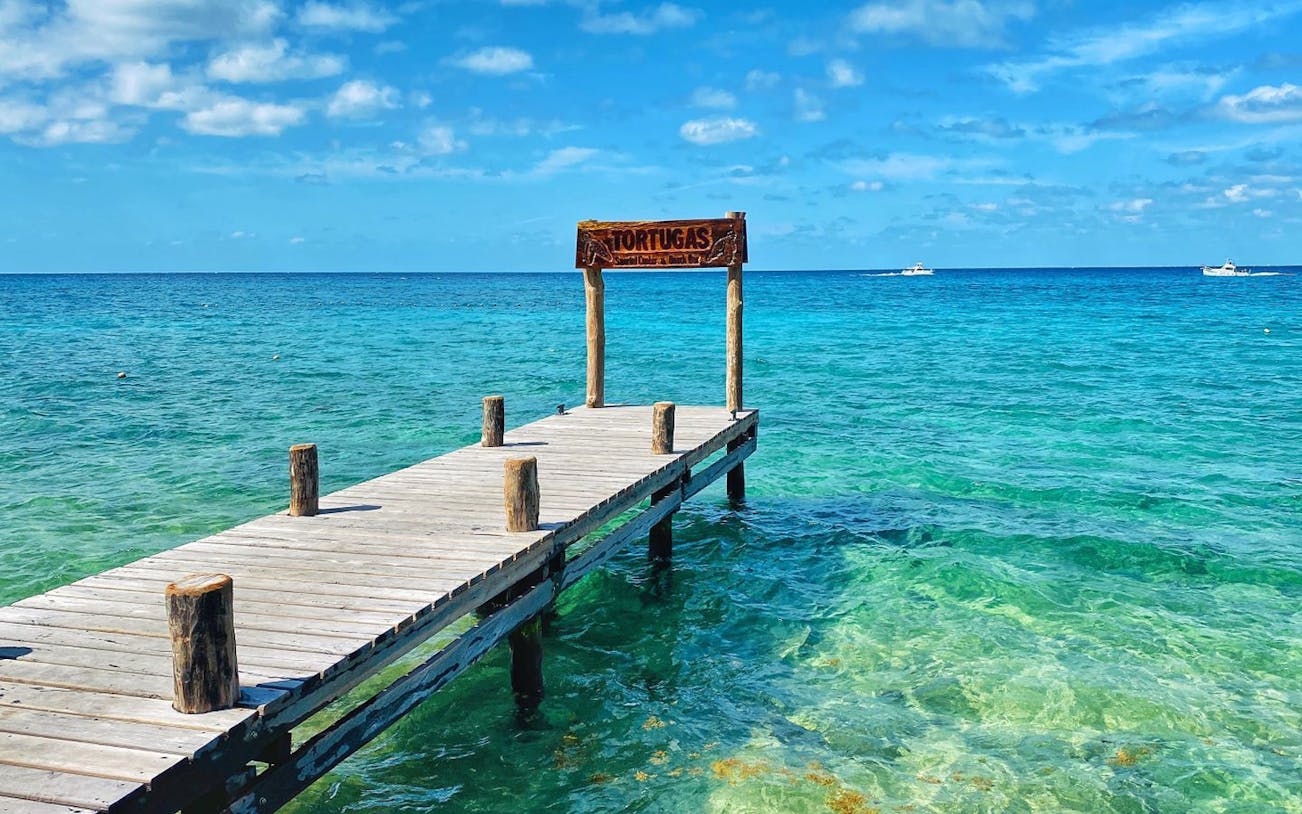 Dock extending into clear turquoise waters at El Cielo, Cozumel, Mexico.