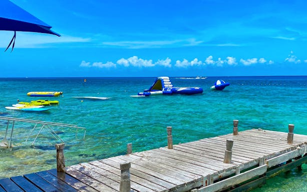 Floating water park and dock in clear blue ocean for ATV Mud Kicking and Snorkeling Experience.