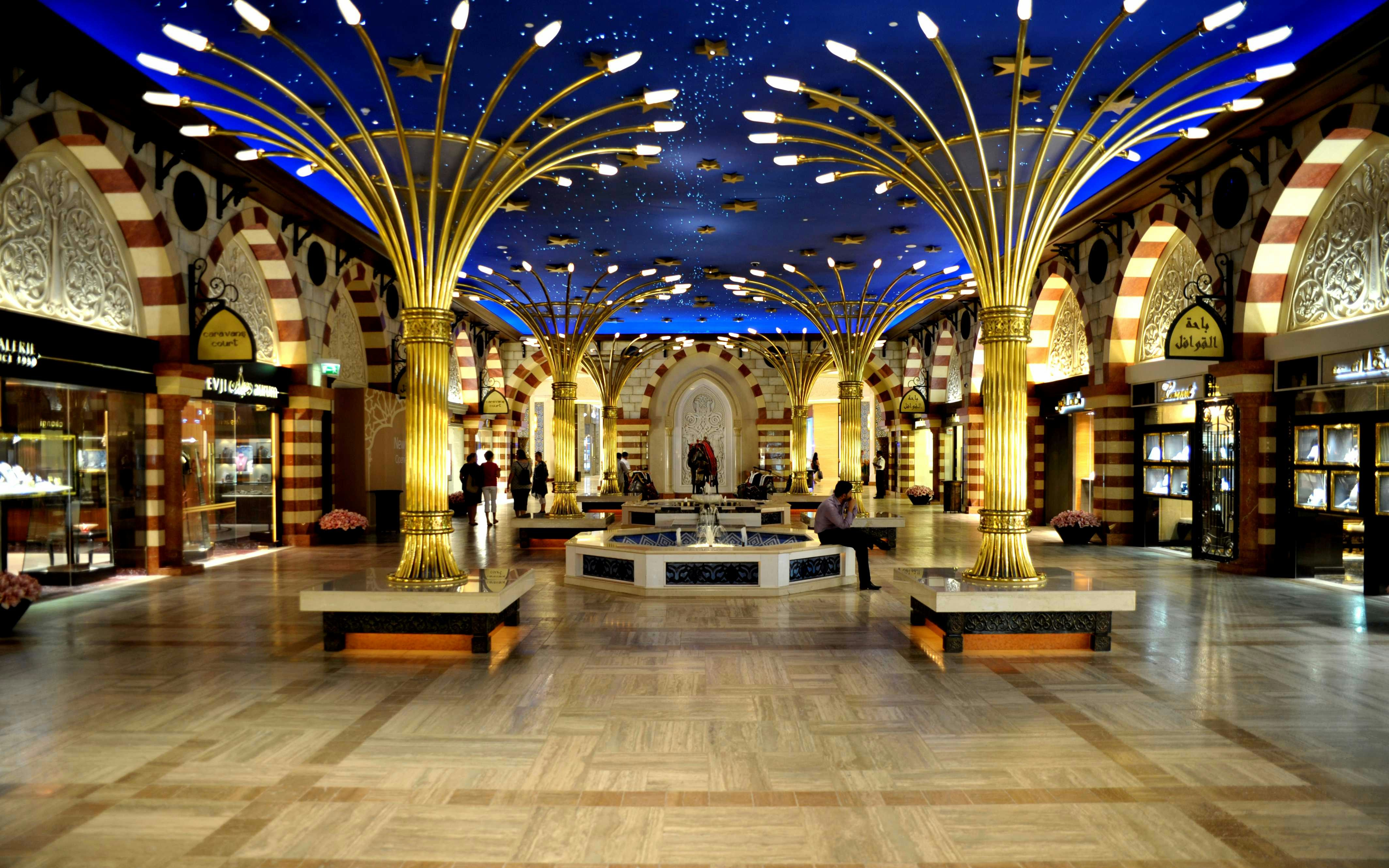 Dubai souk interior with ornate columns and starry ceiling, showcasing luxury shops.