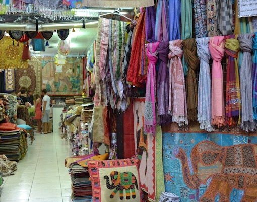 Colorful textiles and scarves displayed in a Dubai souk shop.