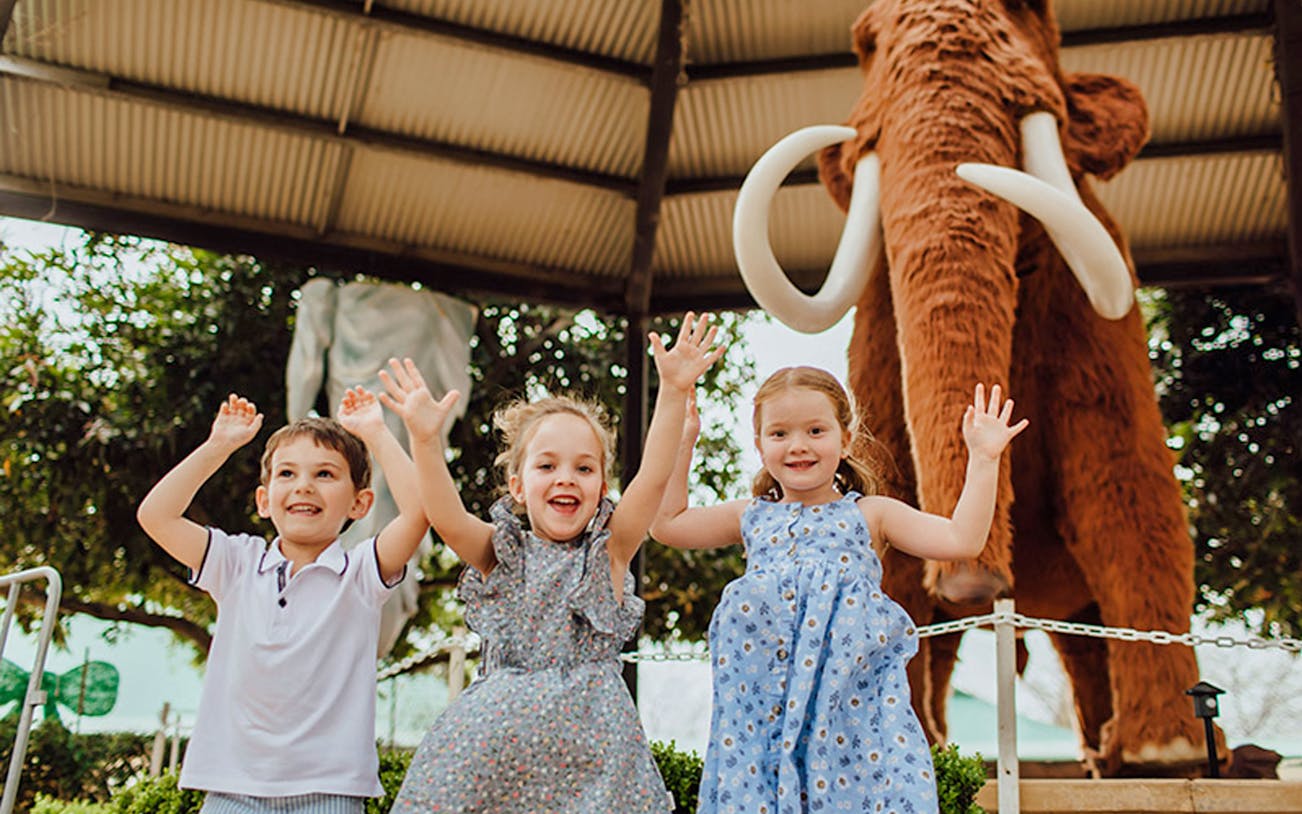 Children enjoying Mega Creatures Event at Hunter Valley Gardens with a mammoth statue.