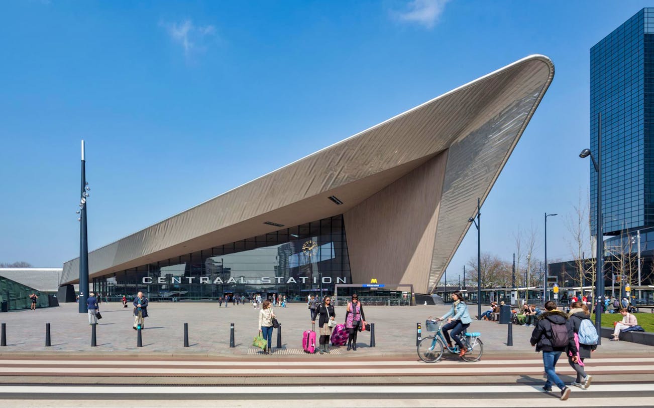 Rotterdam Centraal Station entrance with people walking and cycling.