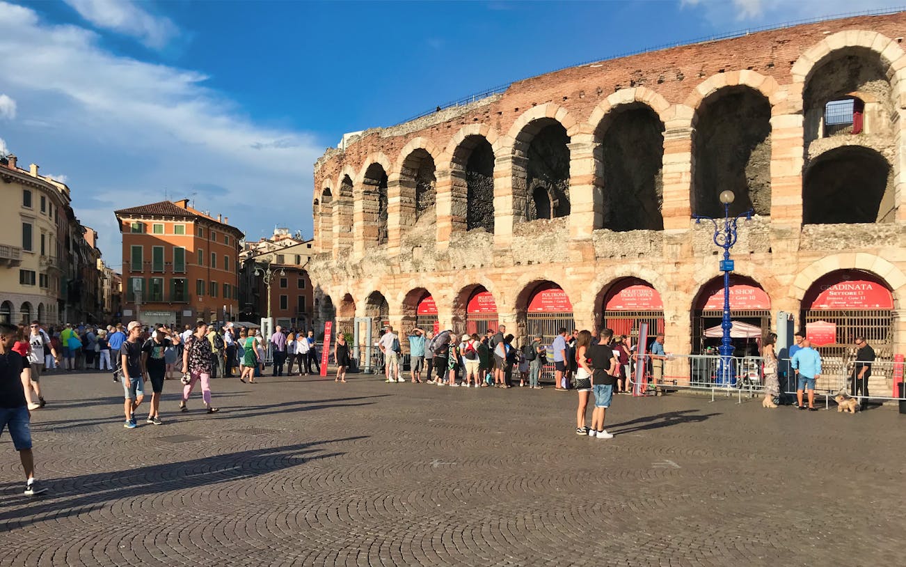 Visitors outside Arena di Verona, Italy, preparing for an opera event and city tour.