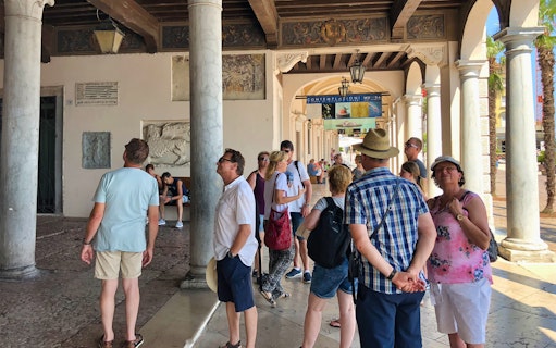 Tourists exploring historic architecture in Salo, Italy during Lake Garda boat cruise.