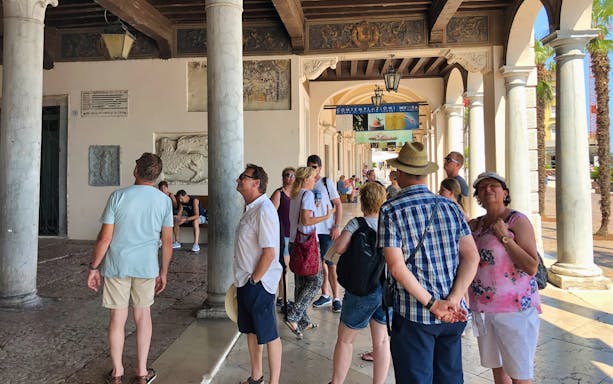 Tourists exploring historic architecture in Salo, Italy during Lake Garda boat cruise.