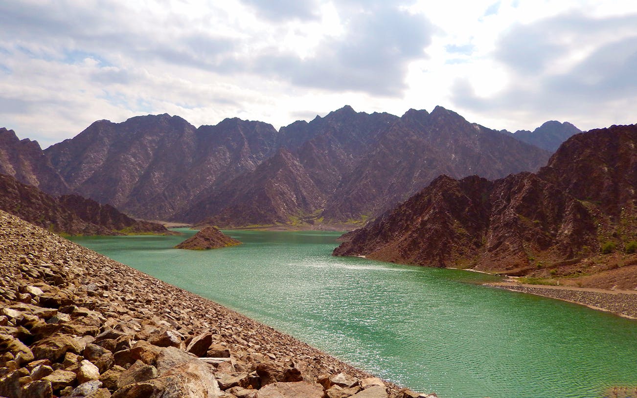 Rocky mountain landscape with a turquoise lake, ideal for a mountain safari adventure.