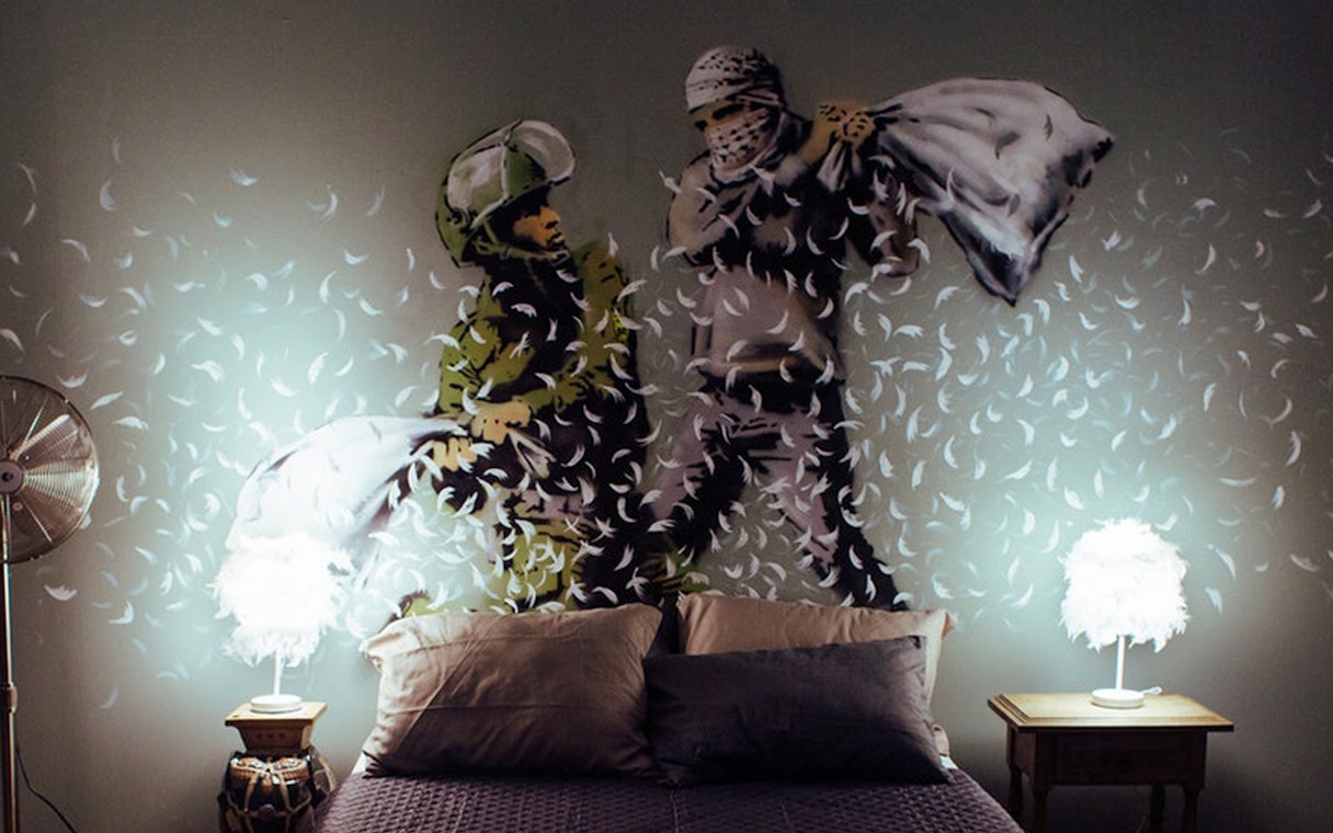 Street art mural of a pillow fight by Banksy at Moco Museum, Amsterdam.