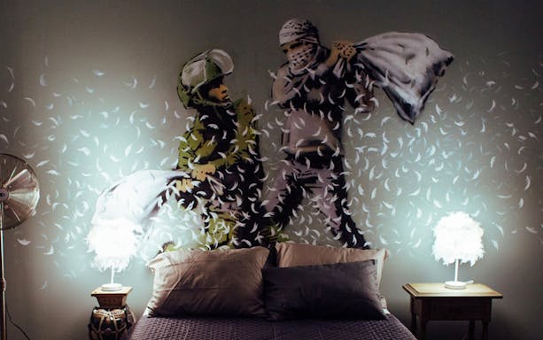 Street art mural of a pillow fight by Banksy at Moco Museum, Amsterdam.