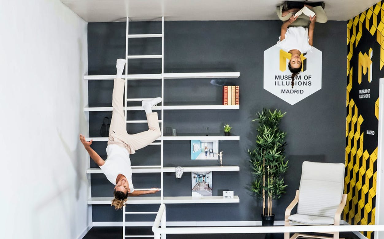 Visitors experiencing an upside-down room at the Museum of Illusions in Madrid.