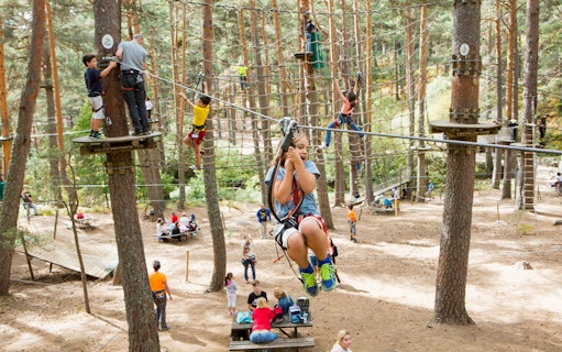 Children zip-lining and climbing at Aventura Amazonia adventure park.