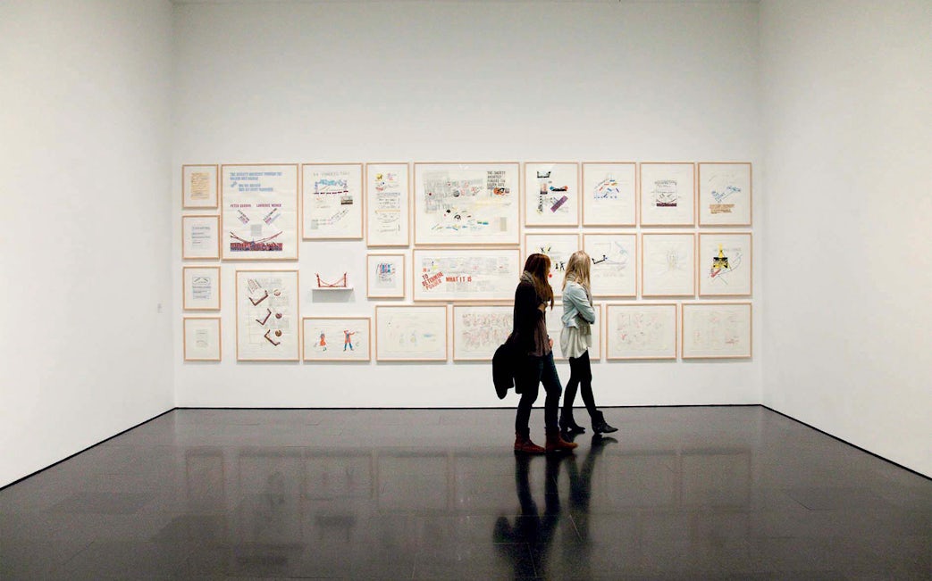 Visitors viewing framed artworks at the Museum of Contemporary Art of Barcelona (MACBA).