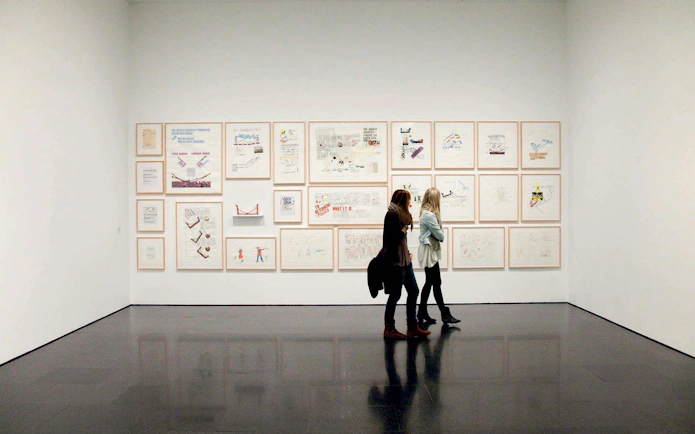 Visitors viewing framed artworks at the Museum of Contemporary Art of Barcelona (MACBA).