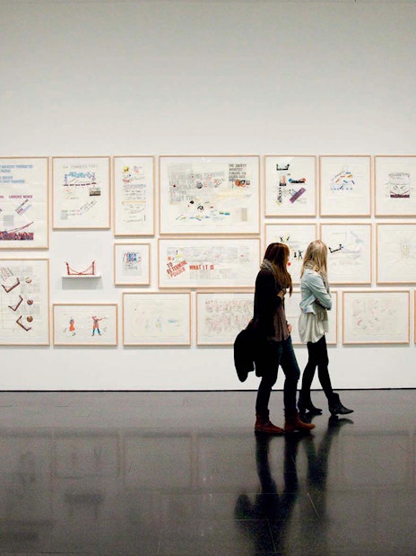 Visitors viewing framed artworks at the Museum of Contemporary Art of Barcelona (MACBA).
