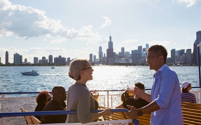 People enjoying a boat tour with the Chicago skyline in the background.