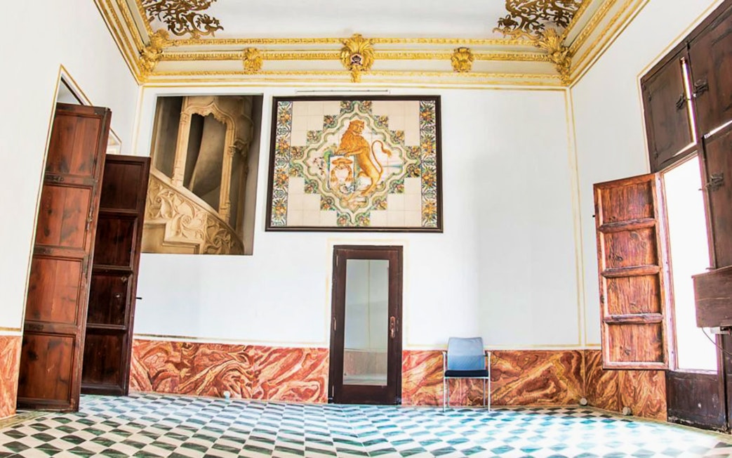 Interior of Silk Museum in Valencia with ornate ceiling and decorative wall tiles.