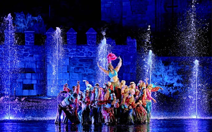 Performers in colorful costumes during El Sueño de Toledo night show at Puy du Fou España.
