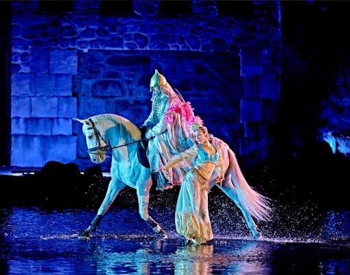 Puy du Fou España entrance with visitors and El Sueño de Toledo night show backdrop, Madrid.