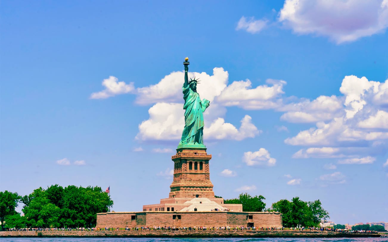 Statue of Liberty on Liberty Island, New York City, under a blue sky.