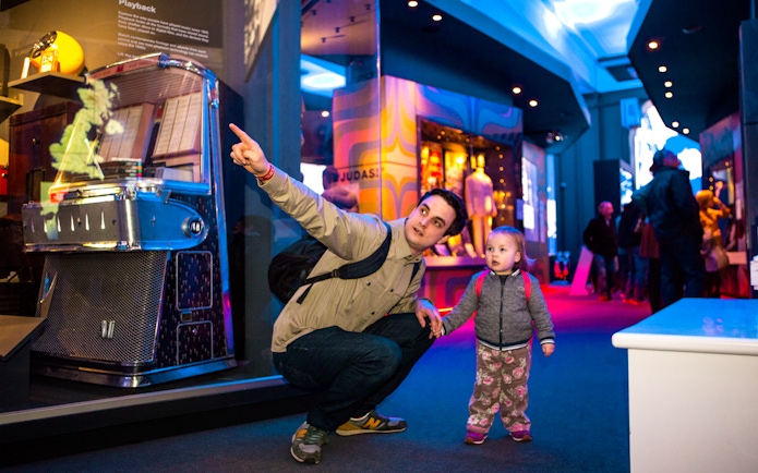 Man and child exploring exhibits at the British Music Experience in London.