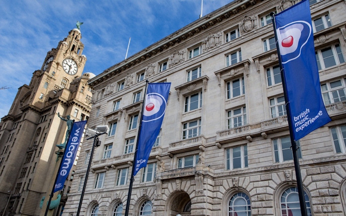 British Music Experience flags outside historic building in Liverpool.