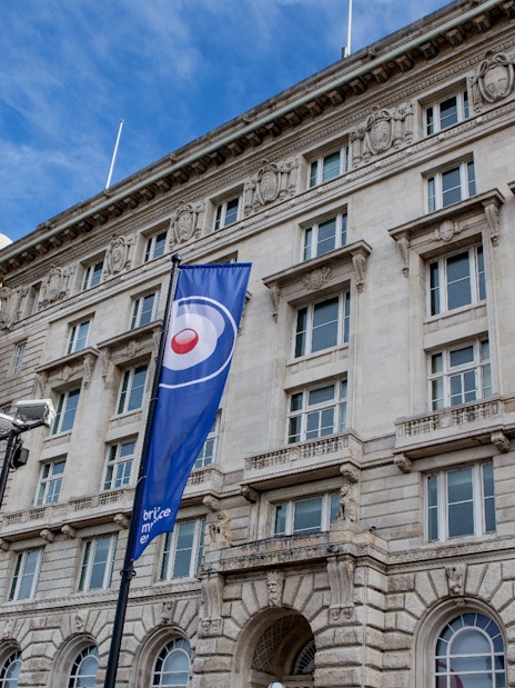 British Music Experience flags outside historic building in Liverpool.