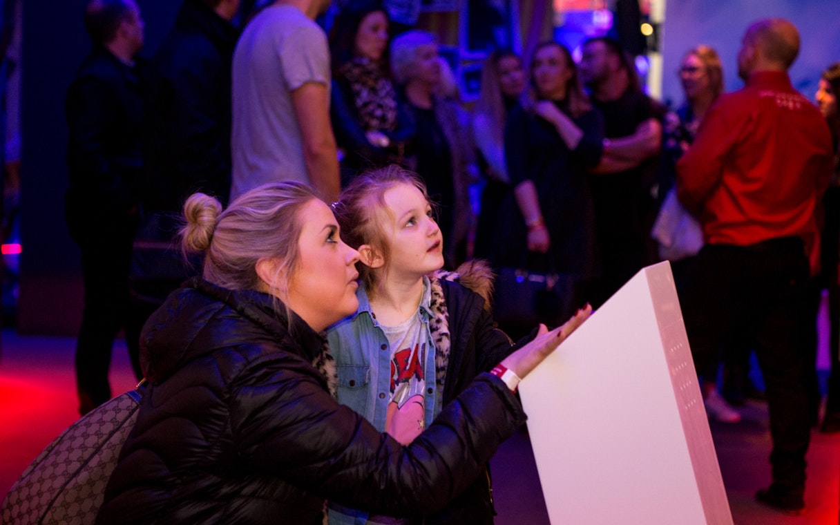 Visitors engaging with an exhibit at the British Music Experience.