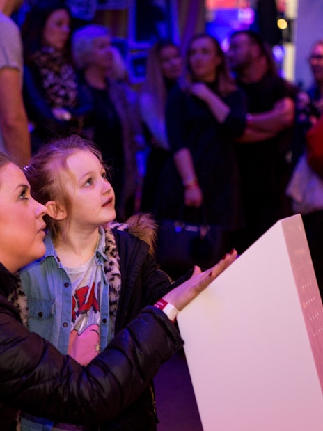 Visitors engaging with an exhibit at the British Music Experience.