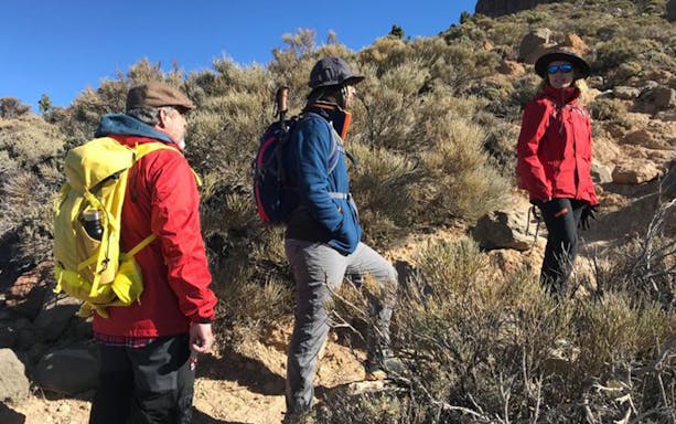 Hikers on a trail near Mount Teide, heading to Pico Viejo viewpoint.