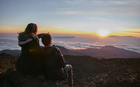 Couple watching sunrise from Mount Teide with view of Pico Viejo, Tenerife.