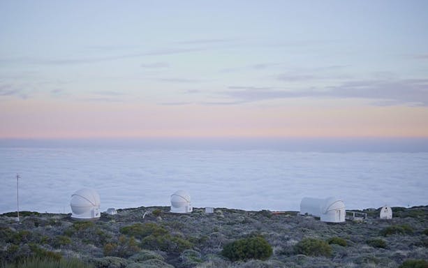 Observatories on Mount Teide at sunset with clouds below, Tenerife.