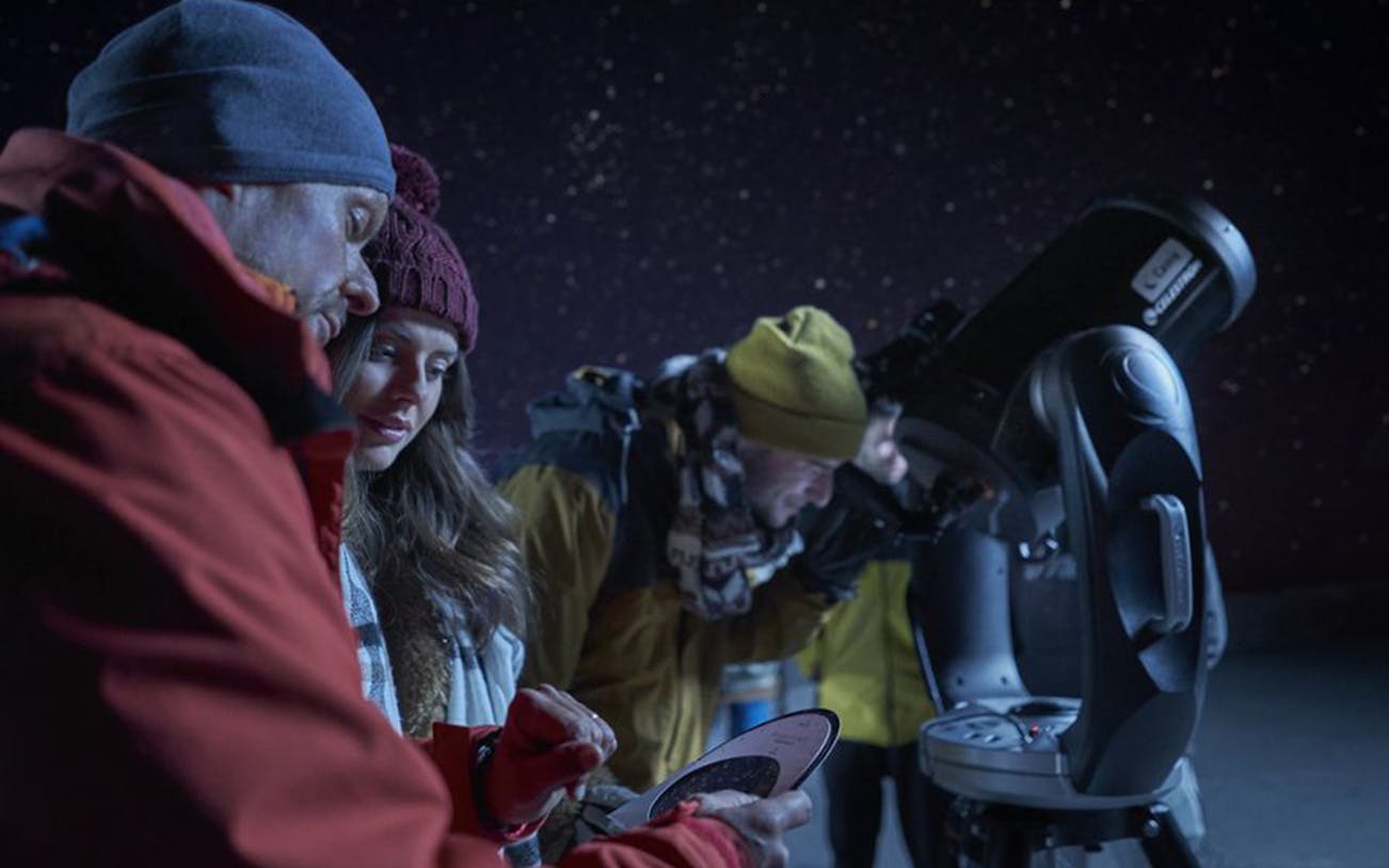 Stargazers using a telescope during Mount Teide sunset and stars observation tour.