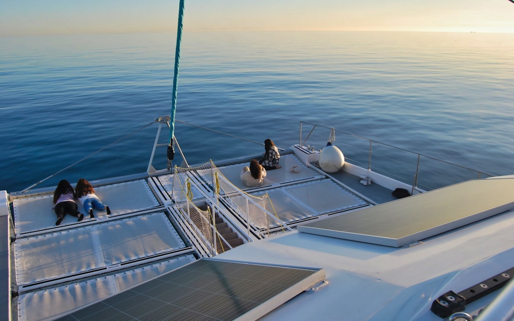 Catamaran deck with people relaxing during a boat tour in Malaga.