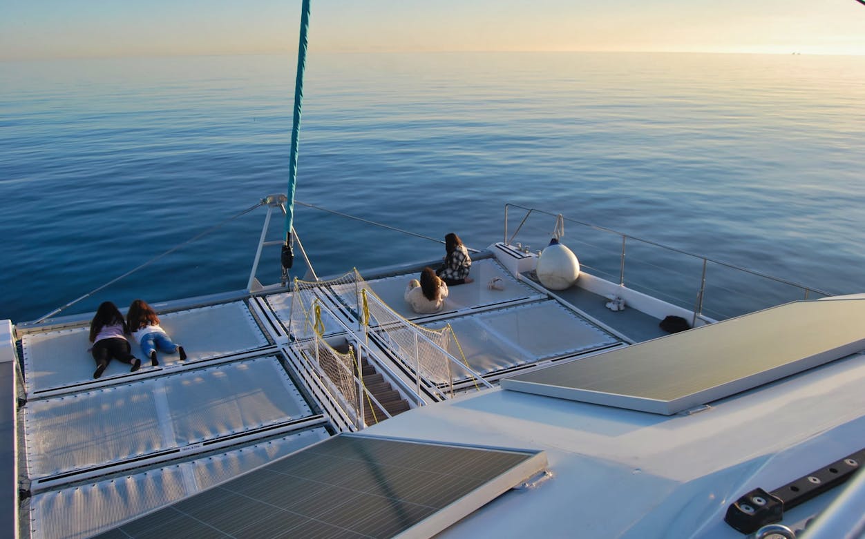 Catamaran deck with people relaxing during a boat tour in Malaga.
