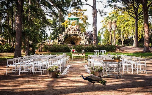 Outdoor seating setup at Parc Samà with a peacock in the foreground.