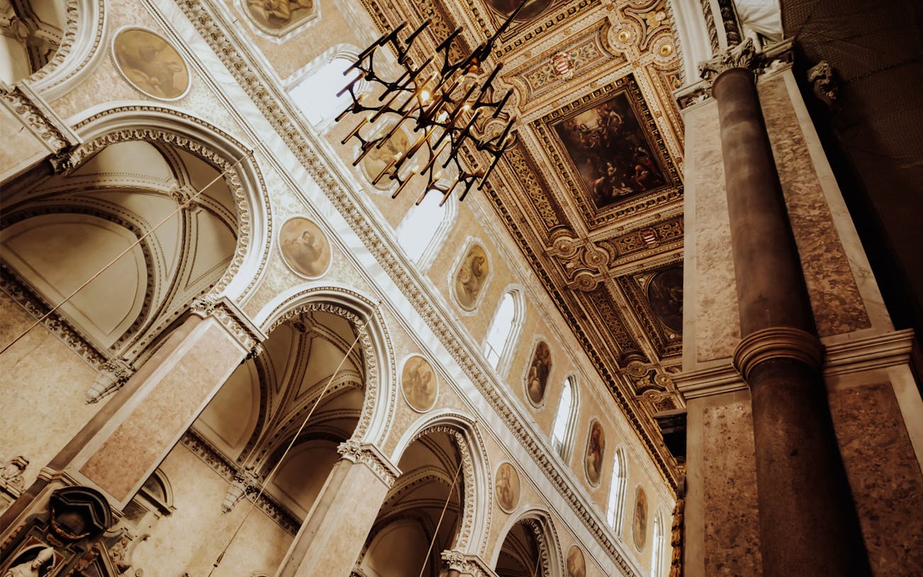 Interior of a historic church in Naples Old Town Centre with ornate ceiling and arches.