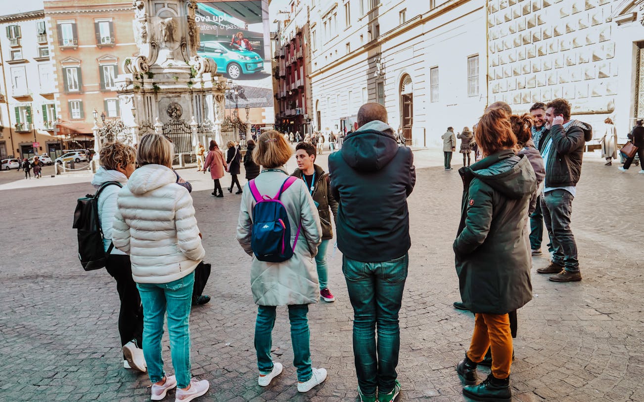 Group of tourists listening to a guide in Naples Old Town Centre.