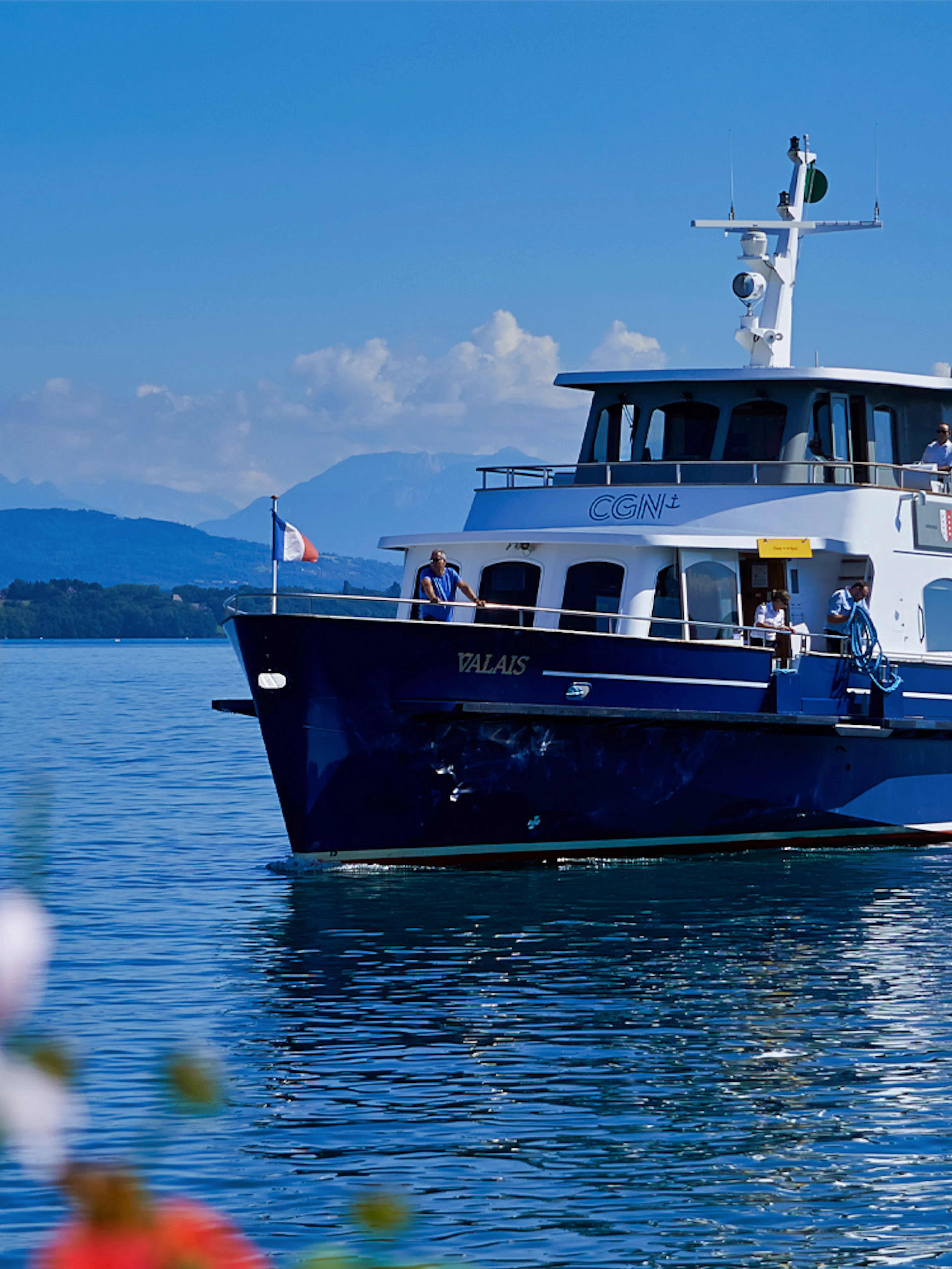 Cruise boat on Lake Geneva with mountains in the background.