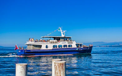 Cruise boat on Lake Geneva with passengers enjoying a sightseeing tour.