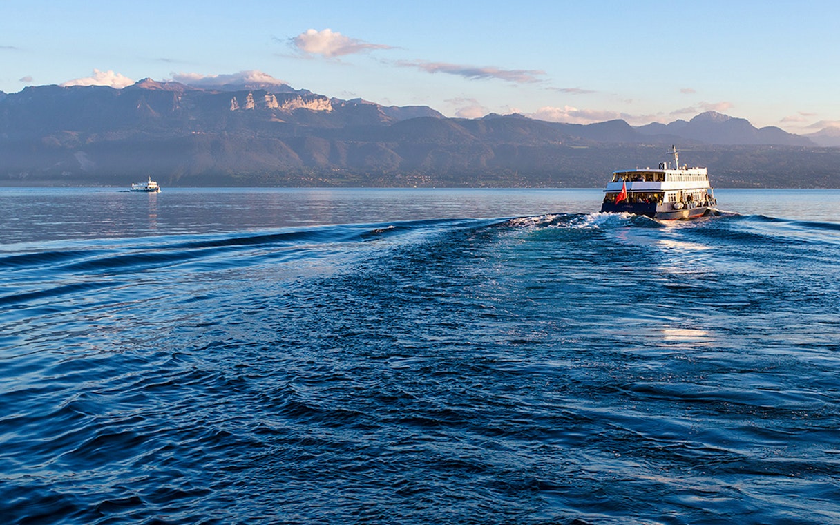 Ferry crossing Lake Geneva from Lausanne to Evian with mountain backdrop.