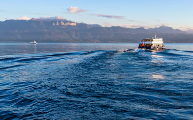 Ferry crossing Lake Geneva from Lausanne to Evian with mountain backdrop.