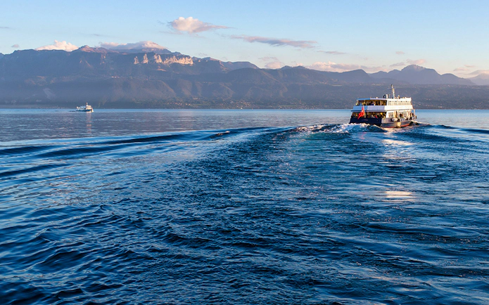 Ferry crossing Lake Geneva from Lausanne to Evian with mountain backdrop.